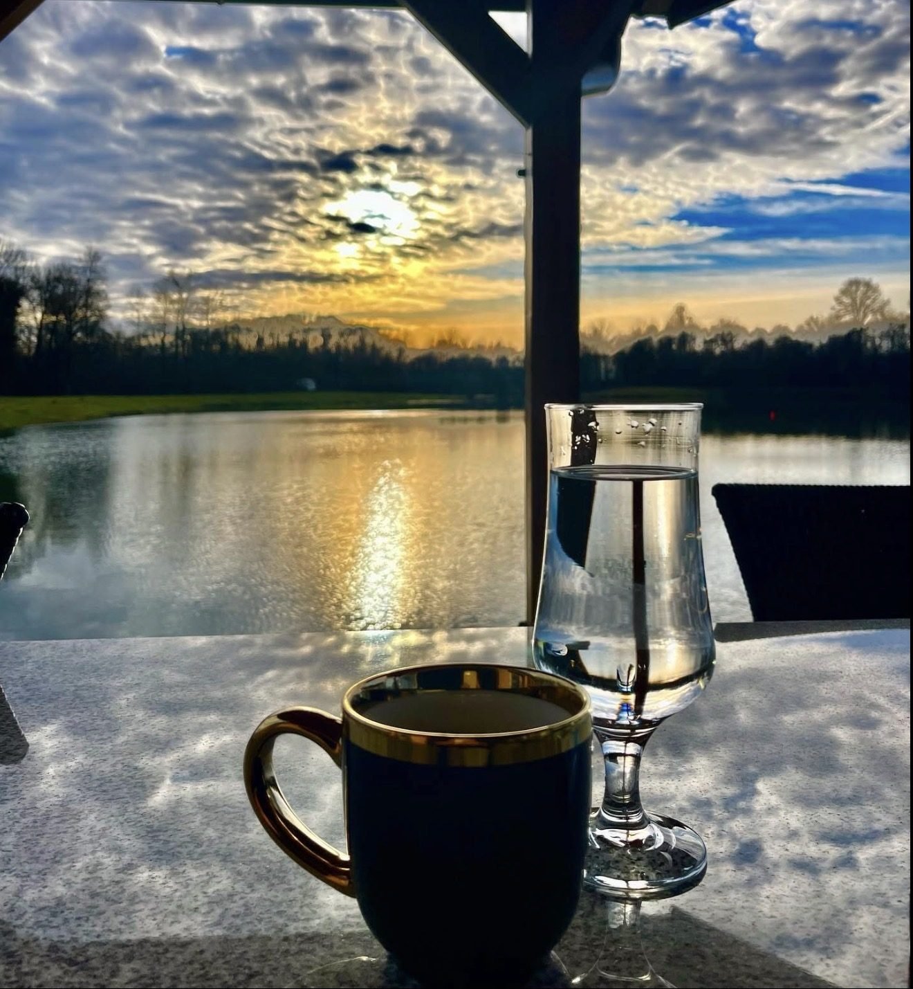 Kafa na terasi uz jezero u zalazak sunca